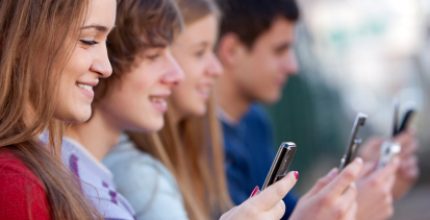 Young men and women holding mobile phones